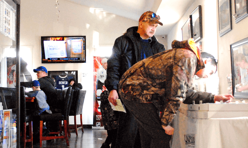 People checking out the hockey singles at the CloutsnChara store on National Hockey Card Day 2019