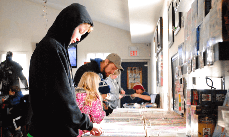 People checking the hockey singles at the CloutsnChara store on National Hockey Card Day 2019